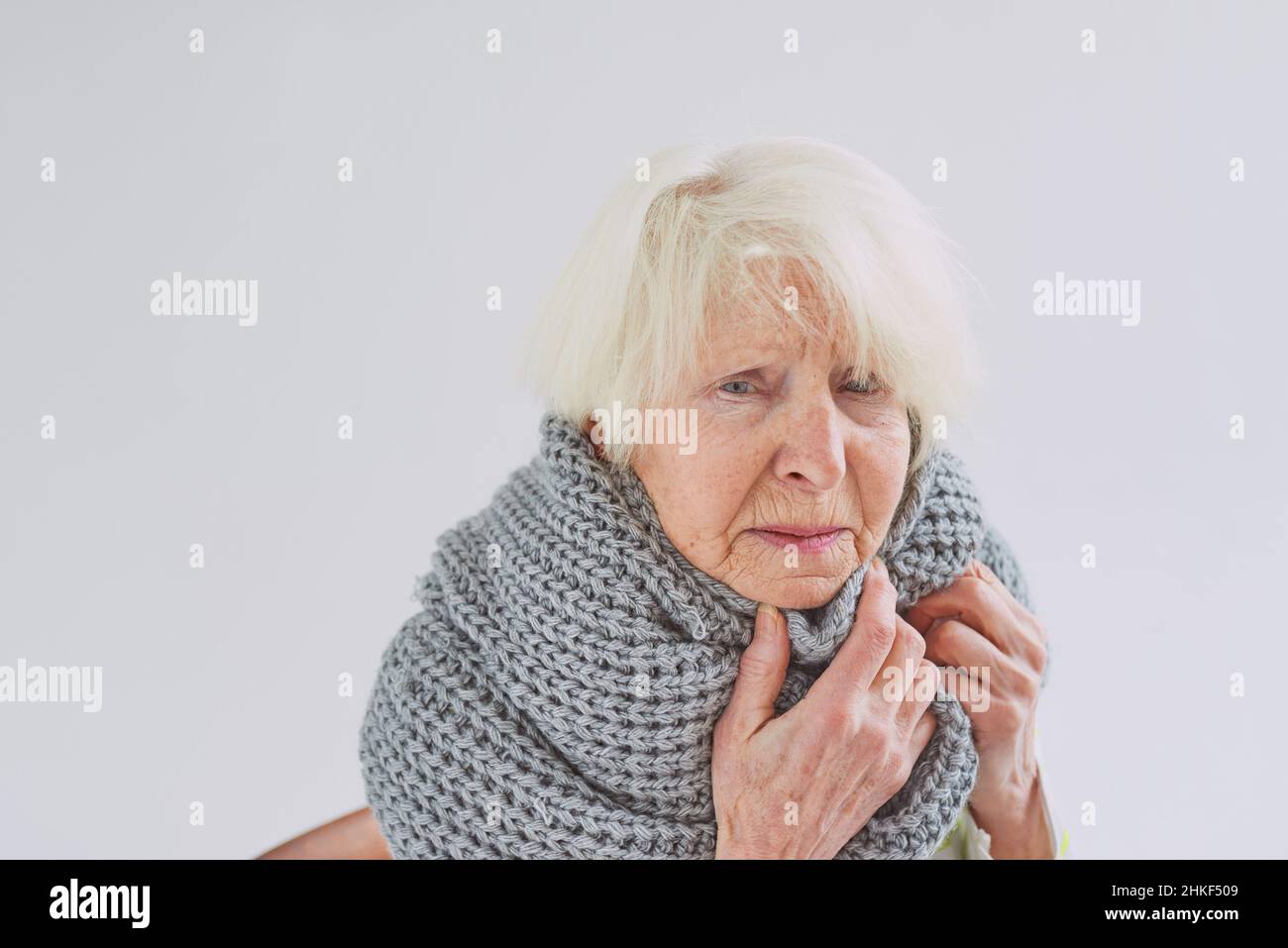 donna malata anziana in sciarpa gelida a casa. Sanità, crisi, concetto di olness Foto Stock
