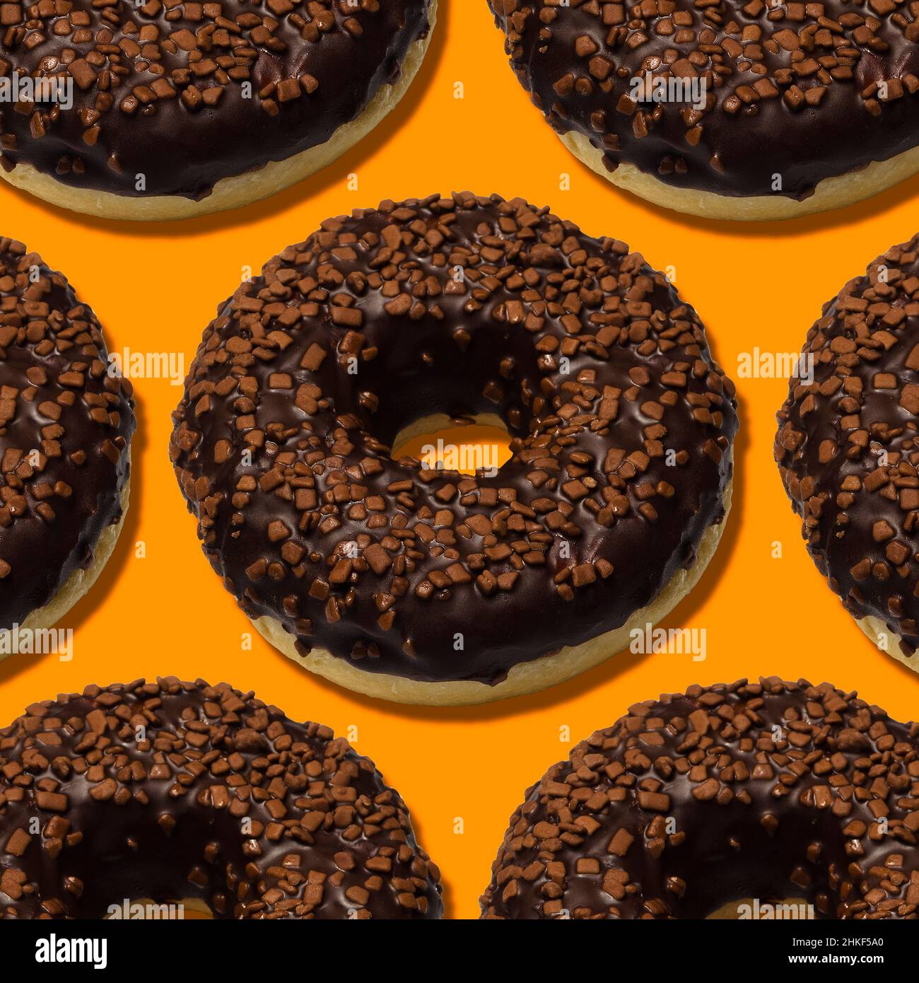 deliziose ciambelle con cioccolato fondente isolato su sfondo arancione Foto Stock