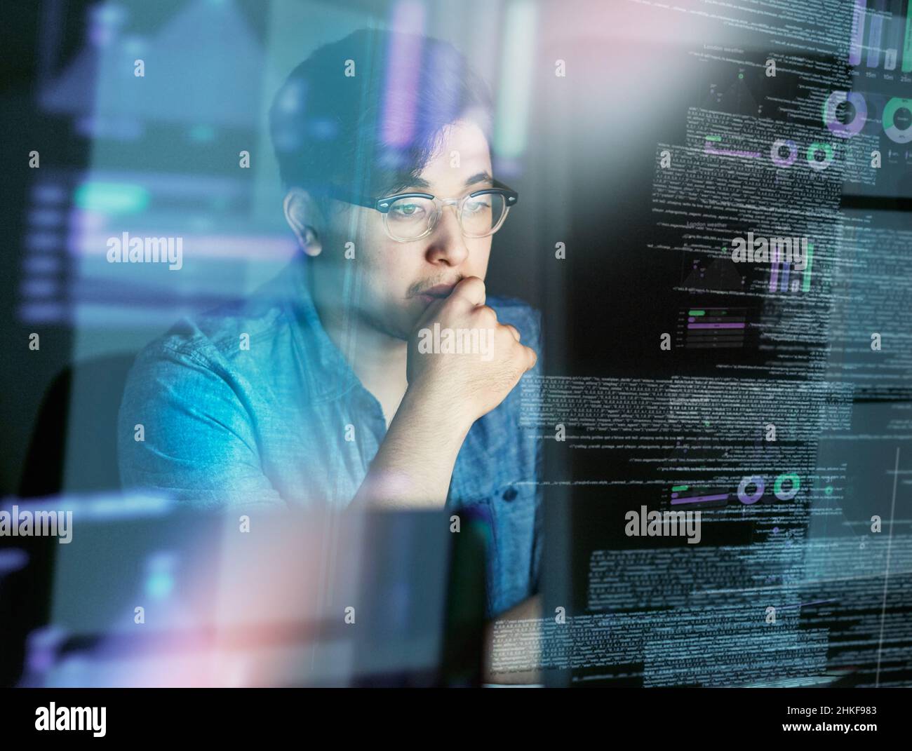 Pensando al codice. Scatto ritagliato di un giovane programmatore di computer che guarda attraverso i dati. Foto Stock