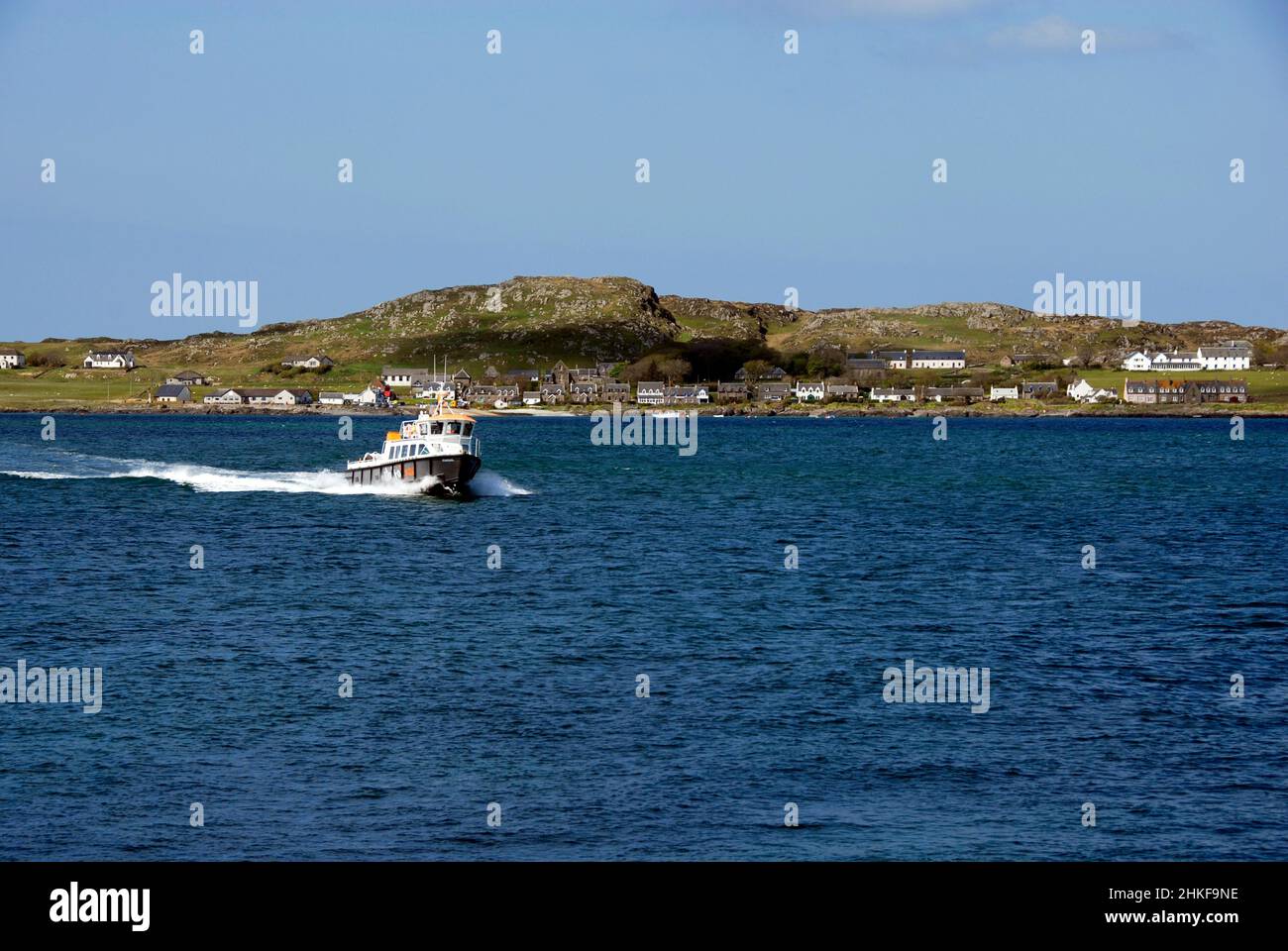 Piccola barca che si sposta rapidamente al largo della costa dell'isola di Iona, Scozia Foto Stock