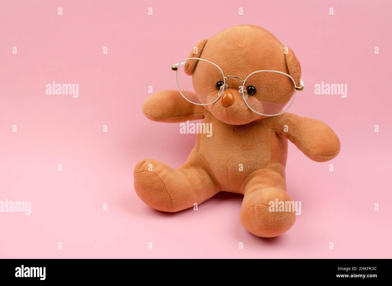 Orsacchiotto in occhiali per la visione su sfondo rosa Foto Stock