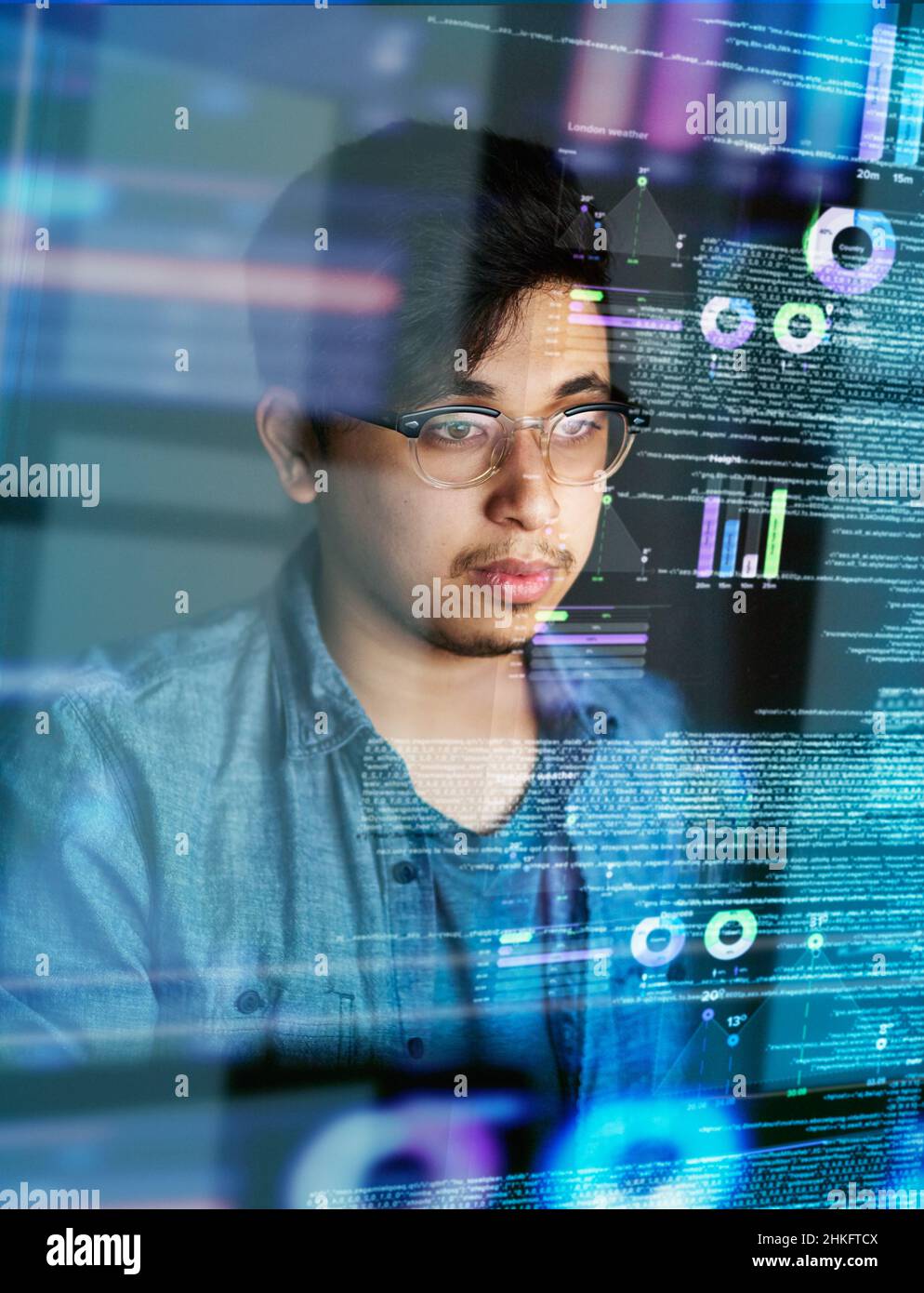 Catturato dal codice. Scatto ritagliato di un giovane programmatore di computer che guarda attraverso i dati. Foto Stock
