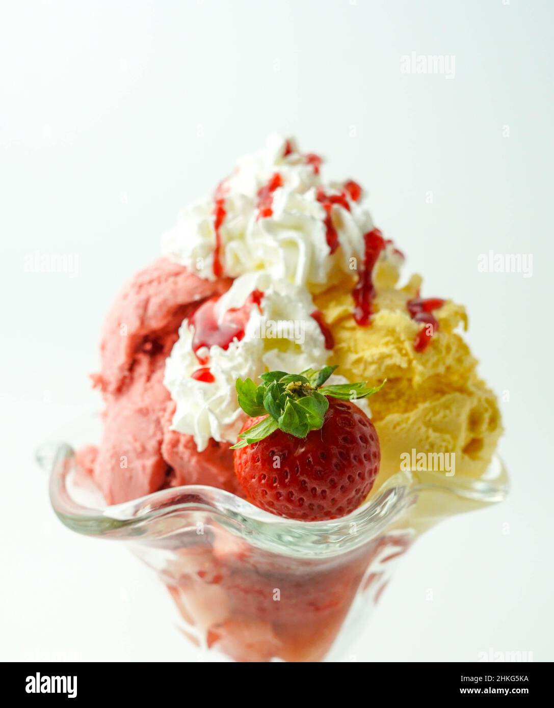 Tazza con tre palline di banana, panna e gelato alla fragola Foto Stock