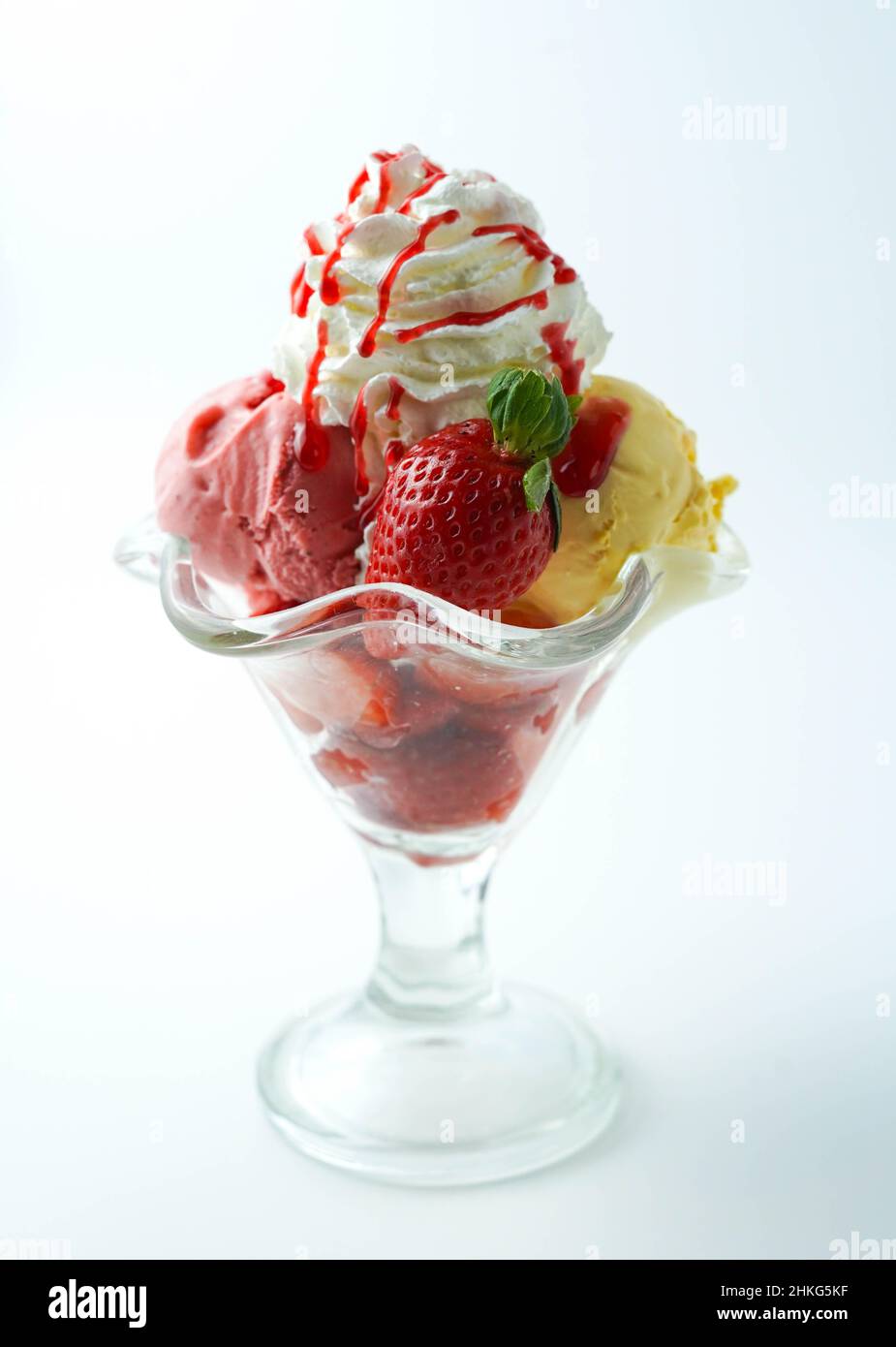 Tazza con tre palline di banana, panna e gelato alla fragola Foto Stock
