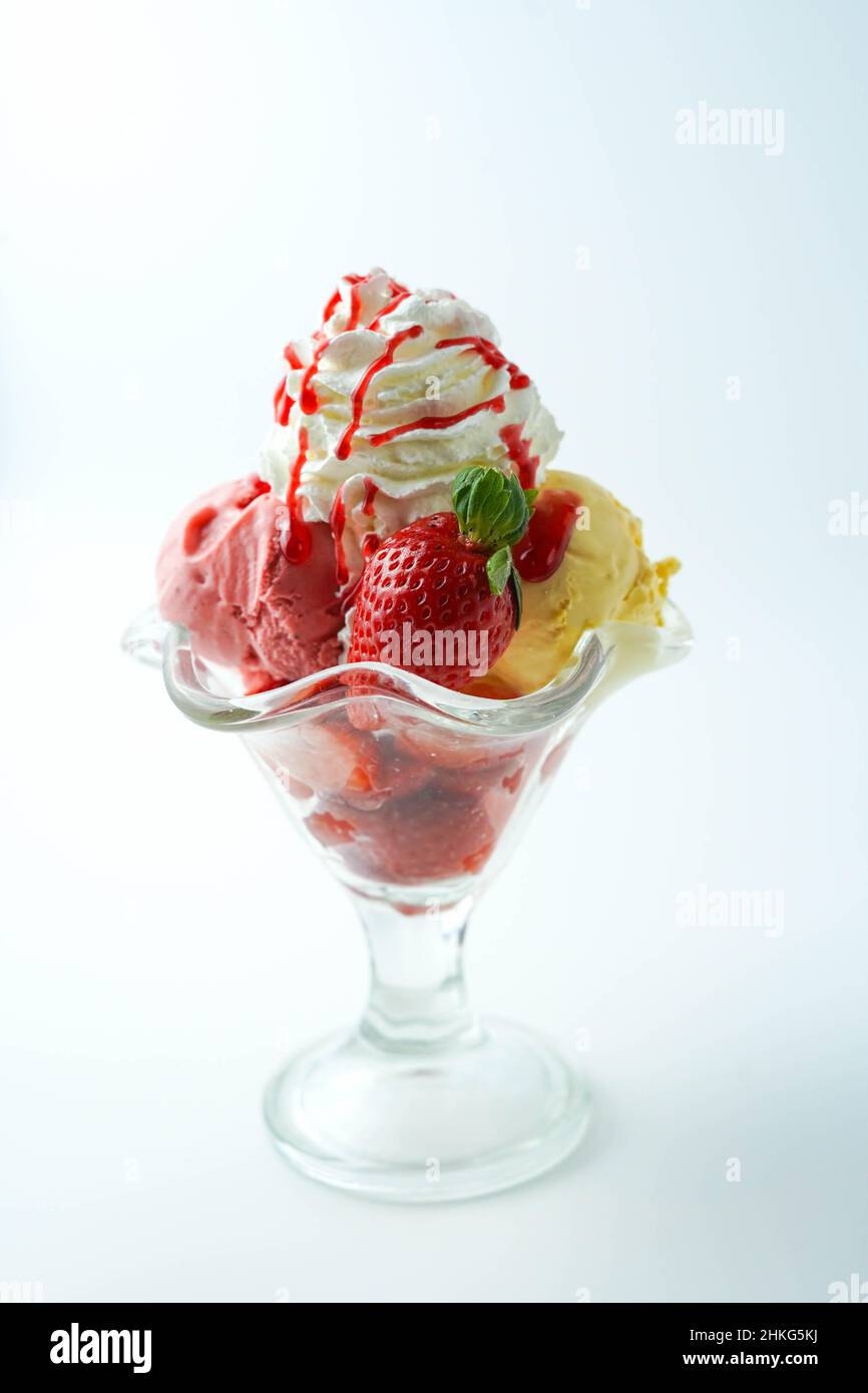 Tazza con tre palline di banana, panna e gelato alla fragola Foto Stock