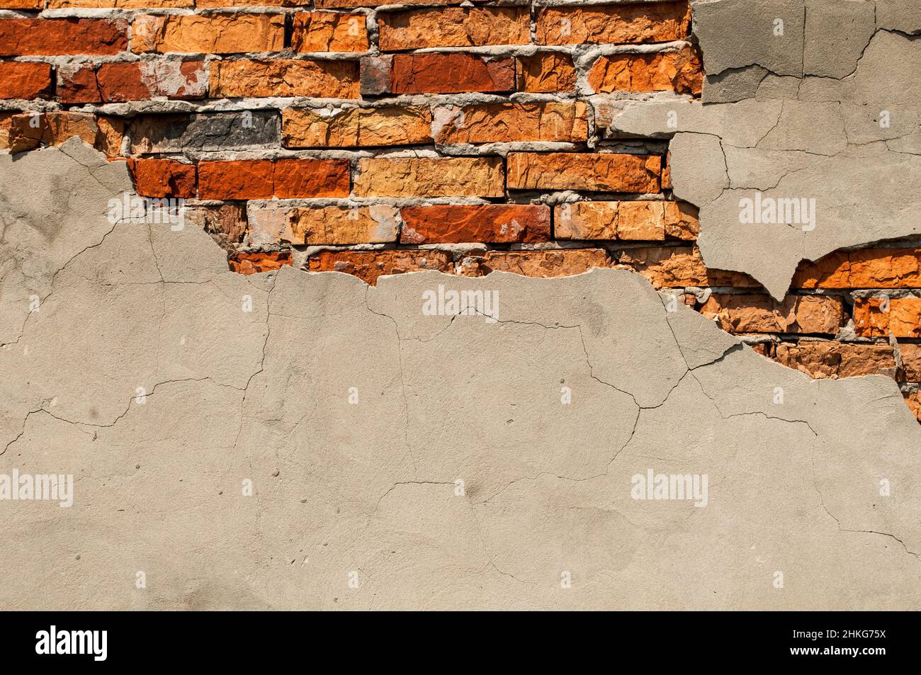 Vecchia parete di mattone con gesso caduto via. Sfondo di crack muro texture Foto Stock