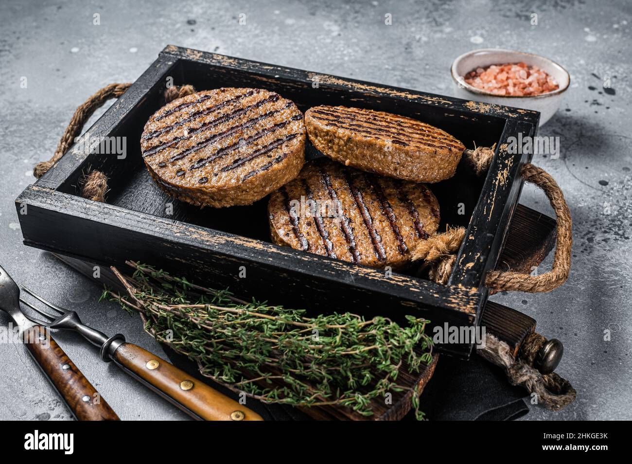 Polpette arrosto senza carne, polpette di hamburger di carne a base di piante in vassoio di legno con erbe. Sfondo grigio. Vista dall'alto Foto Stock