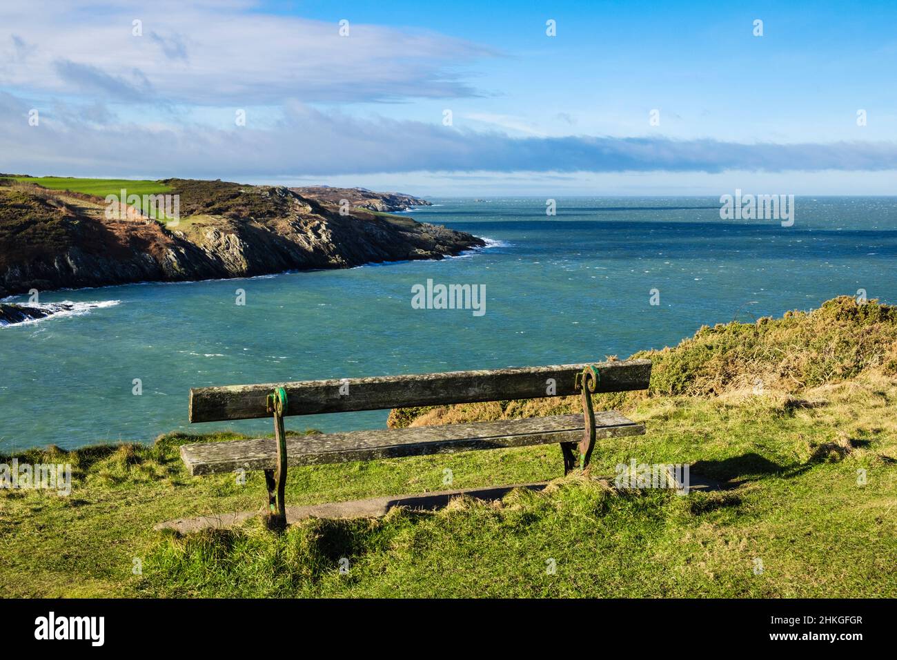 Panca che si affaccia su Porth Eilian con vista lungo la costa rocciosa da Point Lynas. Llaneilian, Amlwch, Isola di Anglesey, Galles del Nord, Regno Unito, Regno Unito Foto Stock
