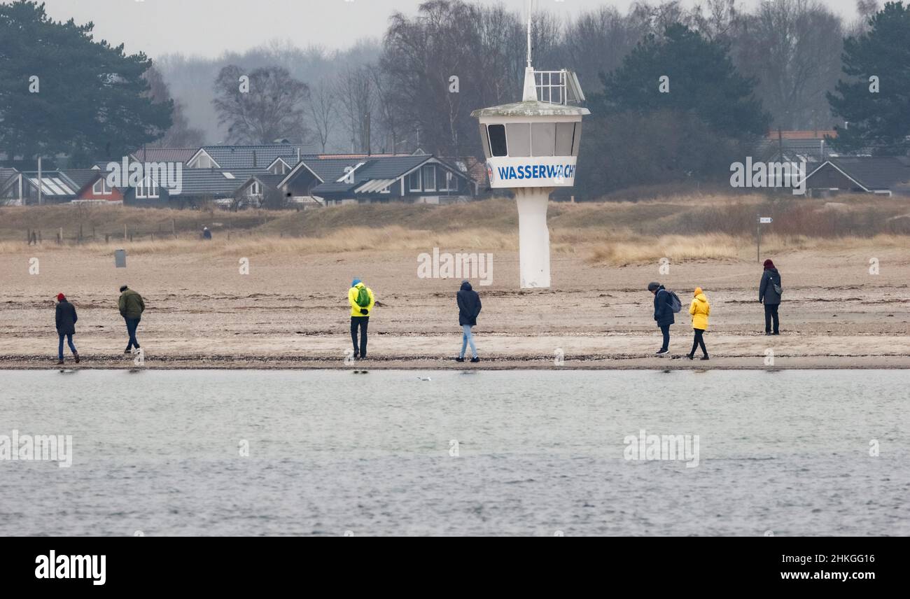 04 febbraio 2022, Schleswig-Holstein, Lübeck-Travemünde: Gli escursionisti si trovano sulla spiaggia di Priball in condizioni di tempo oscuro, quasi senza vento e con una temperatura dell'aria di 4 gradi. Foto: Markus Scholz/dpa Foto Stock