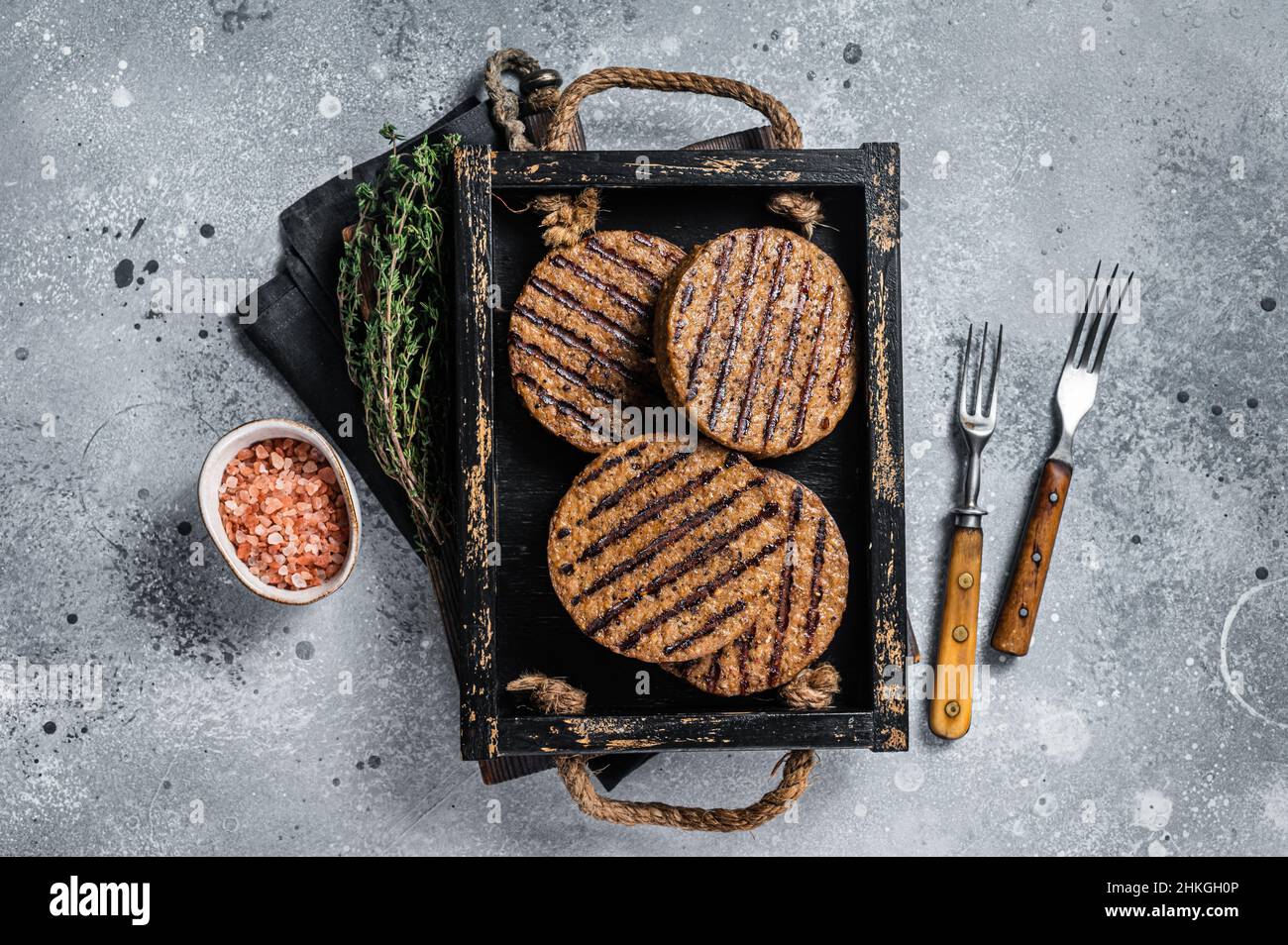 Polpette arrosto senza carne, polpette di hamburger di carne a base di piante in vassoio di legno con erbe. Sfondo grigio. Vista dall'alto Foto Stock