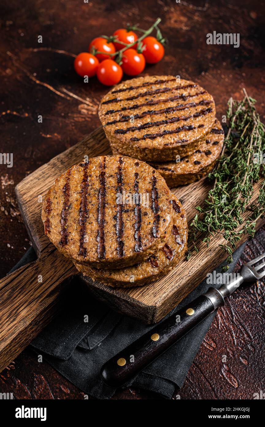 Barbecue grigliate di verdure a base di carne hamburger polpette, tegan cutlets su tavola di legno con erbe. Sfondo scuro. Vista dall'alto Foto Stock