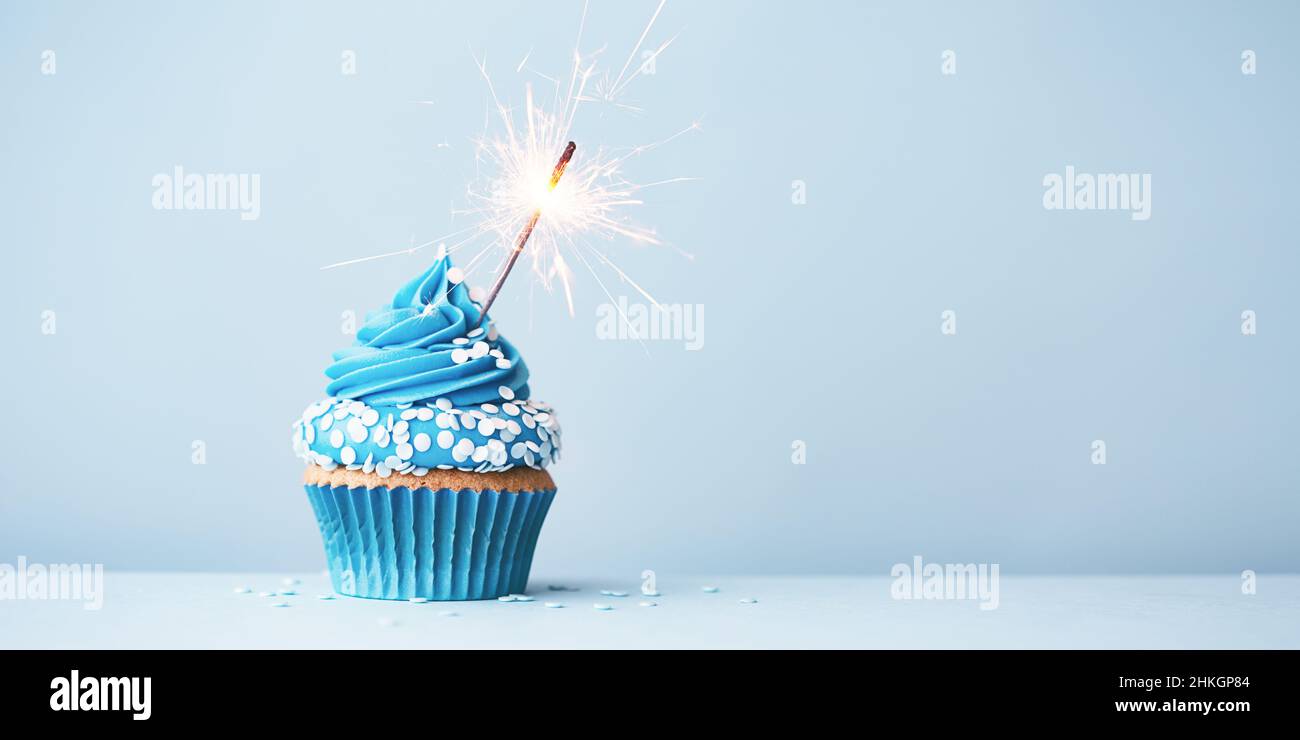 Cupcake di compleanno con festeggiamenti scintillanti e spolverate per una festa di compleanno Foto Stock