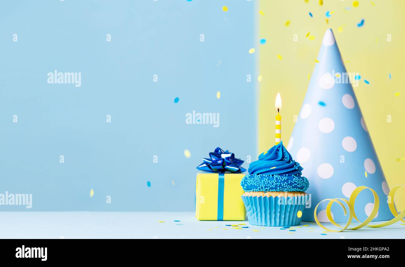 Sfondo cupcake di compleanno con regalo di compleanno, cappello festa di compleanno e confetti caduta Foto Stock