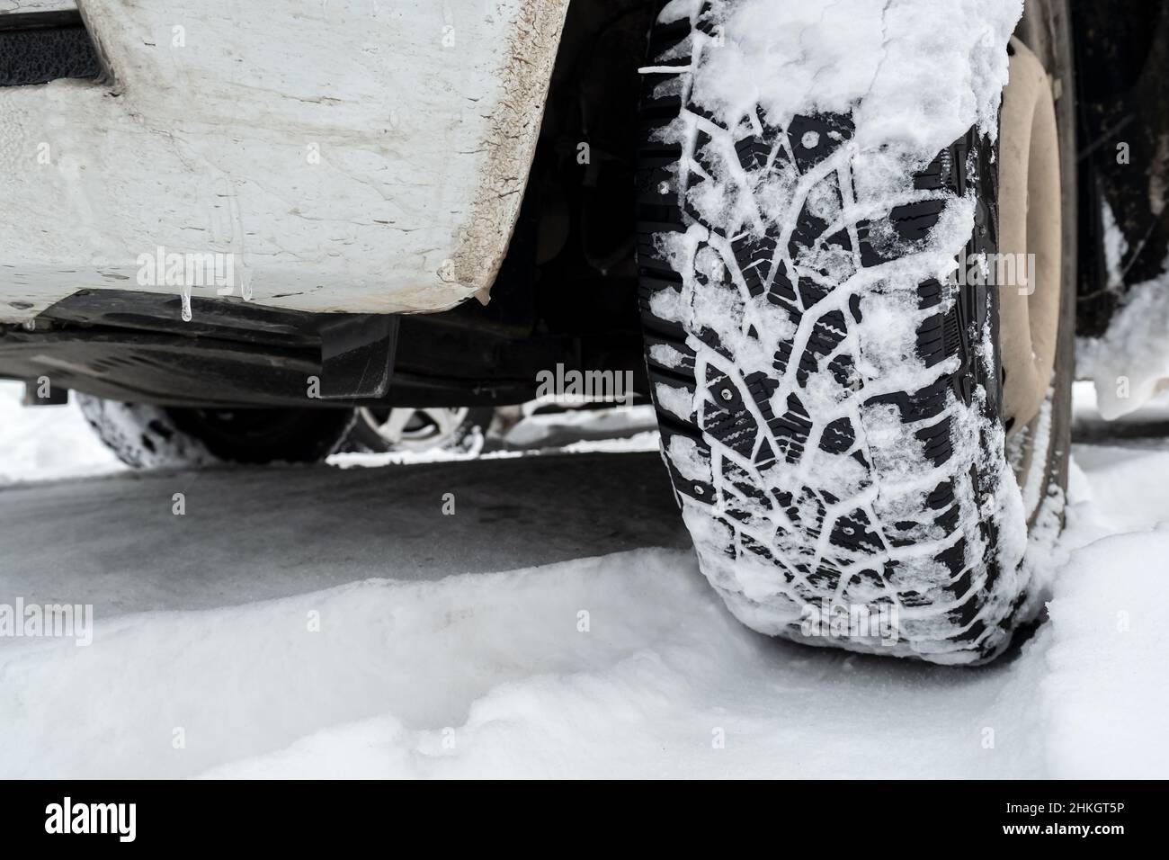 Ruota dell'auto e ingombro su una strada nevosa. Foto Stock