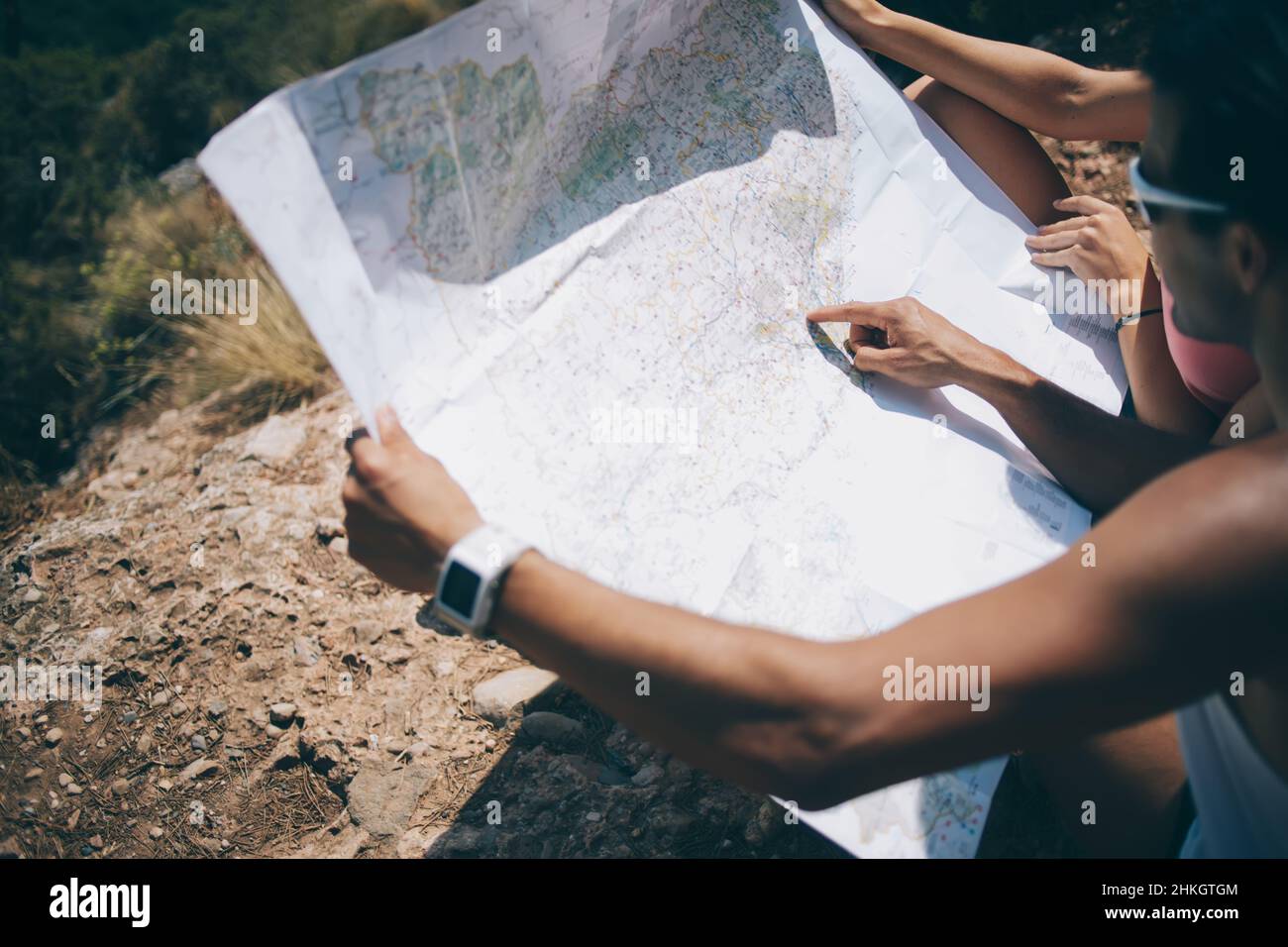 Coppia che esplorano la mappa mentre si siede in collina Foto Stock