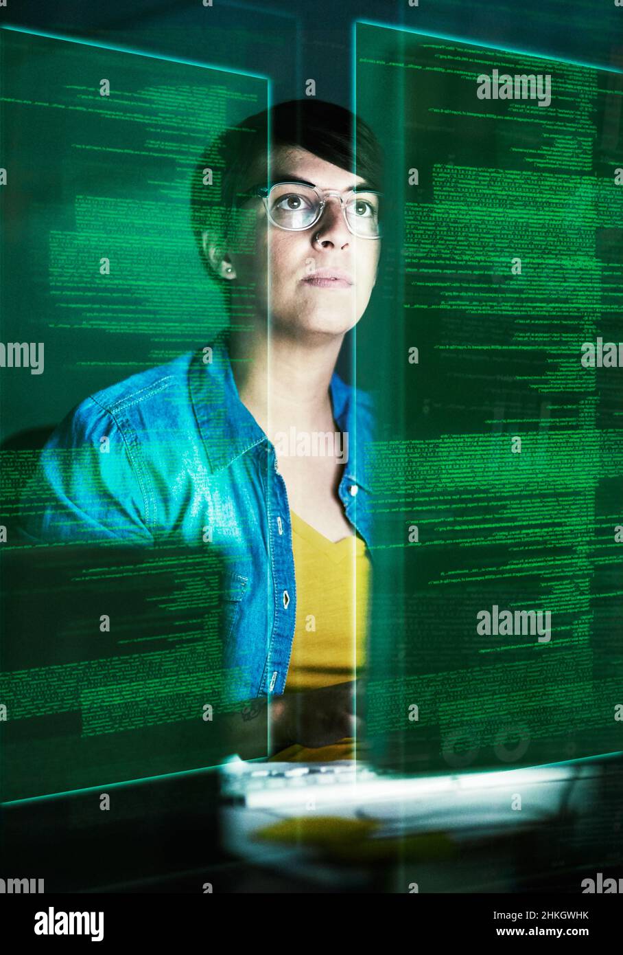 Sta diventando parte della matrice. Scatto ritagliato di un giovane programmatore di computer che guarda attraverso i dati. Foto Stock