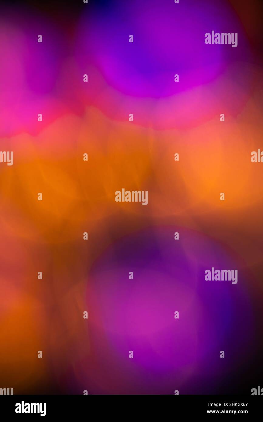 astratto effetto bokeh circolare colorato creato da intenzionalmente fuori fuoco cerchi colorati sovrapposti per creare un colore di fusione sfondo verticale Foto Stock