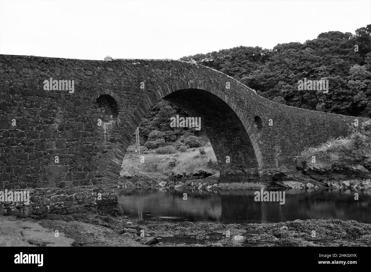 Una vista del vecchio ponte di pietra sull'Atlantico. Una stretta striscia dell'oceano Atlantico che separa la Scozia continentale dall'isola di Seil. Foto Stock