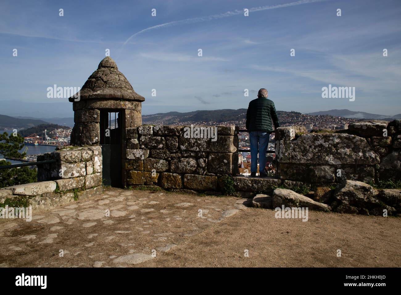 Una persona si affaccia sul muro fortificato del punto di vista del Parque do Monte do Castro a Vigo Foto Stock