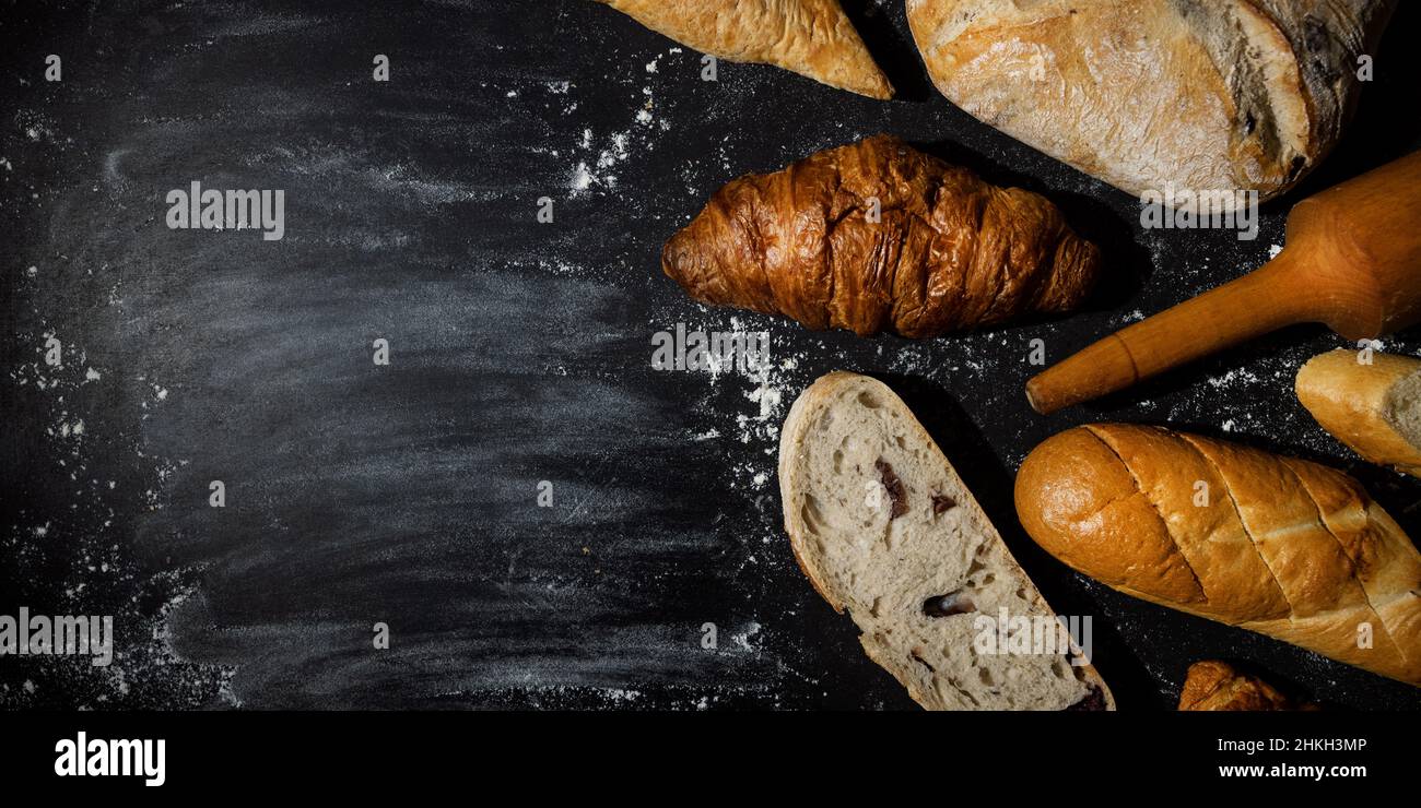 panetteria - pane e prodotti di pasticceria al forno con farina su sfondo nero. spazio copia banner Foto Stock