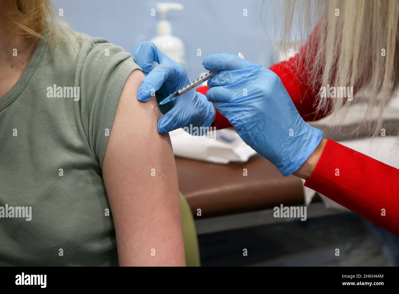 Un vaccinatore di NHS, somministra il jab di richiamo di Pfizer Covid-19 alla donna, in un centro di vaccinazione. Foto Stock