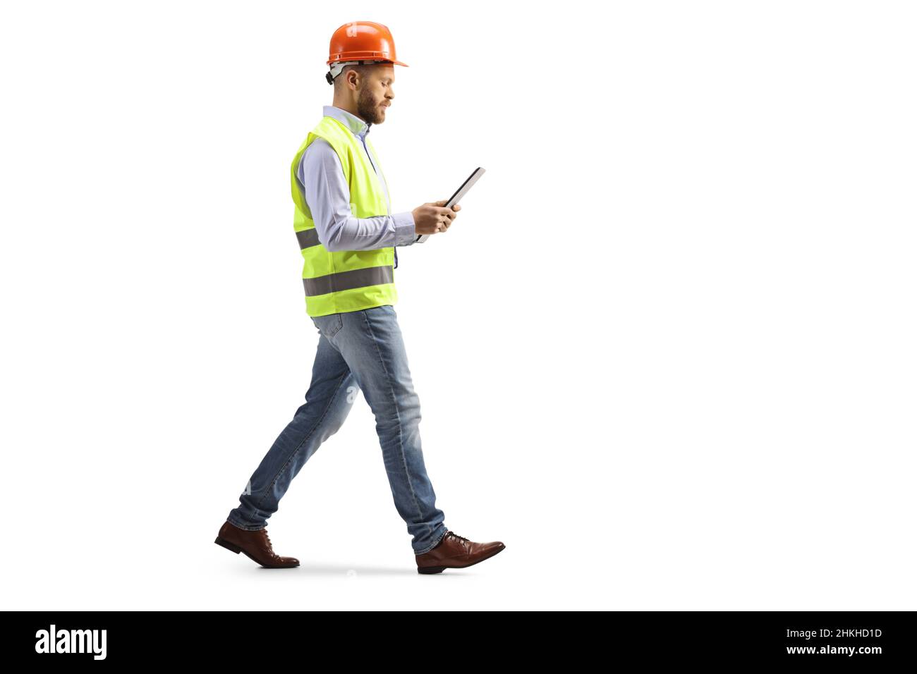 Ingegnere con un hardhat camminare e leggere un documento isolato su sfondo bianco Foto Stock