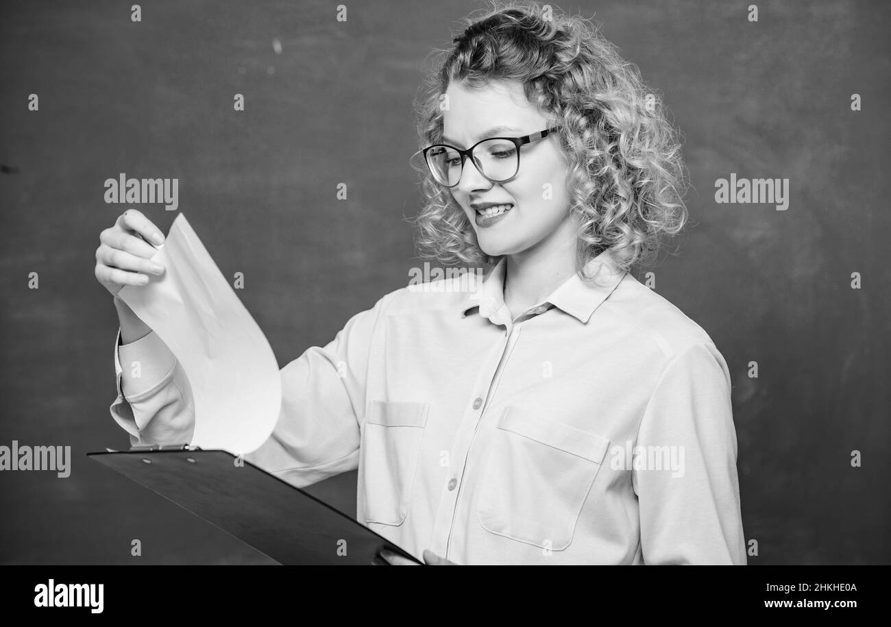 Leggere l'impressing RESUME. Il tutor controlla le esercitazioni. Saggio preventivo dei richiedenti. Progetto scolastico. L'insegnante di letteratura legge la composizione. Donna signora intelligente Foto Stock