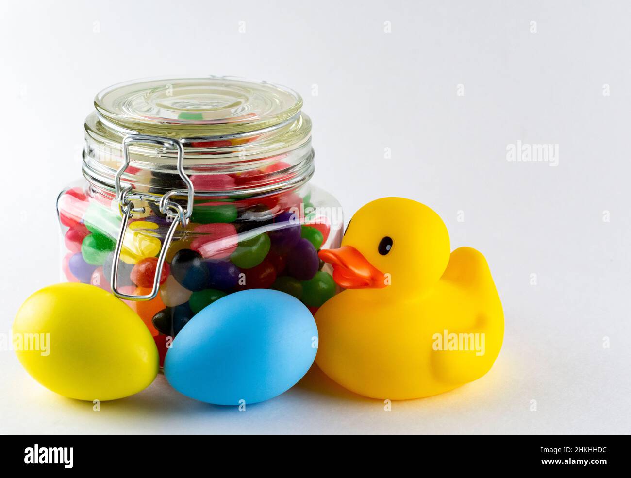 Vasetto di pappa assortita con uova di Pasqua e anatra di gomma su sfondo bianco. Foto Stock