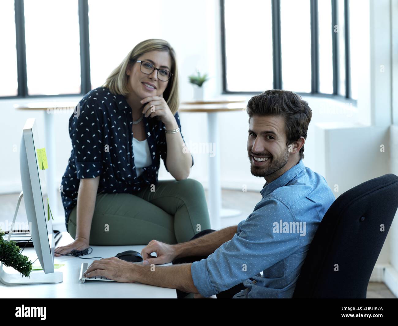 Ritratto ritagliato di due colleghi di lavoro che chiacchierano alla scrivania del loro ufficio Foto Stock