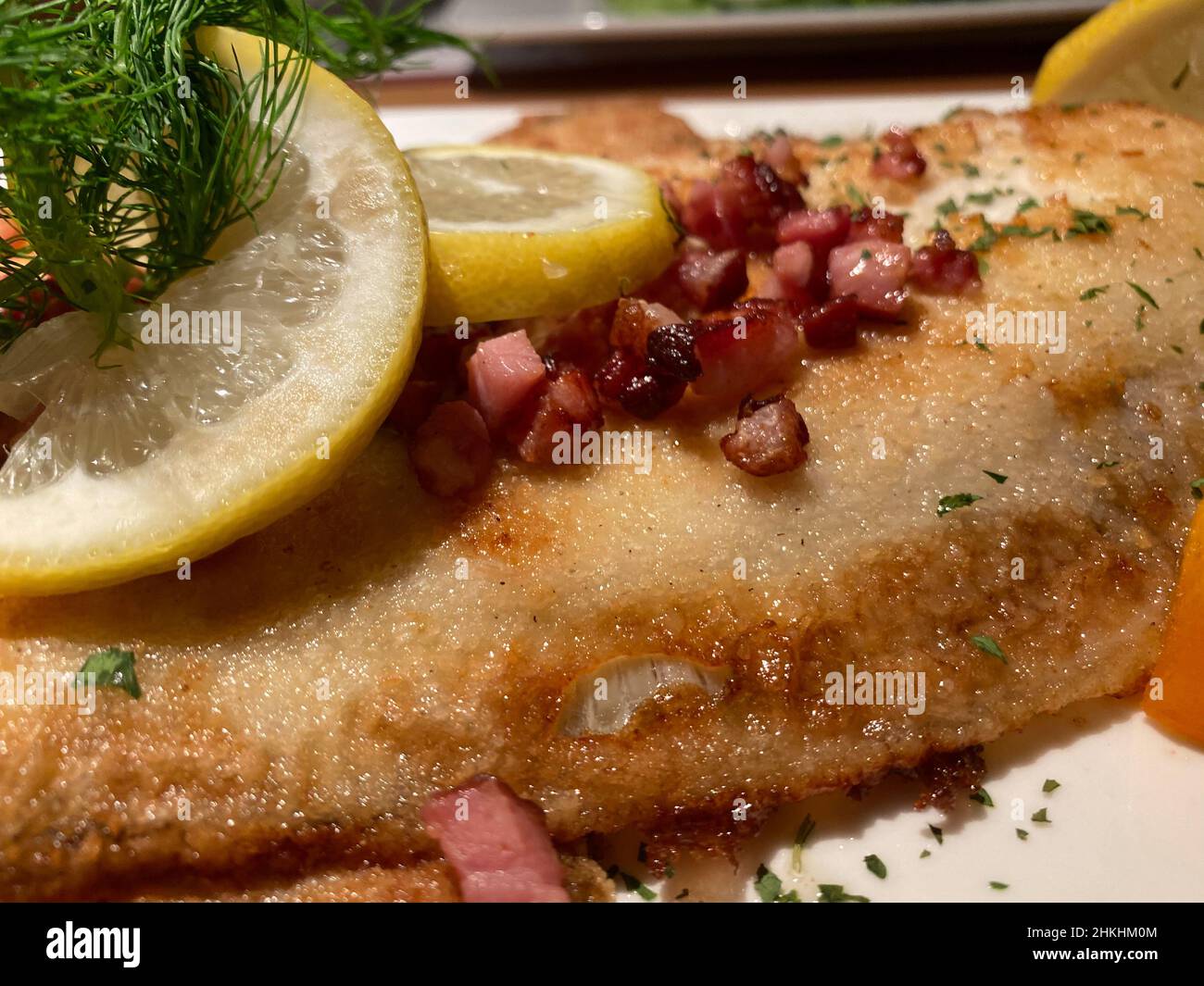 Passera di mare con cubetti di pancetta e limone, ricetta tedesca dalla costa Foto Stock