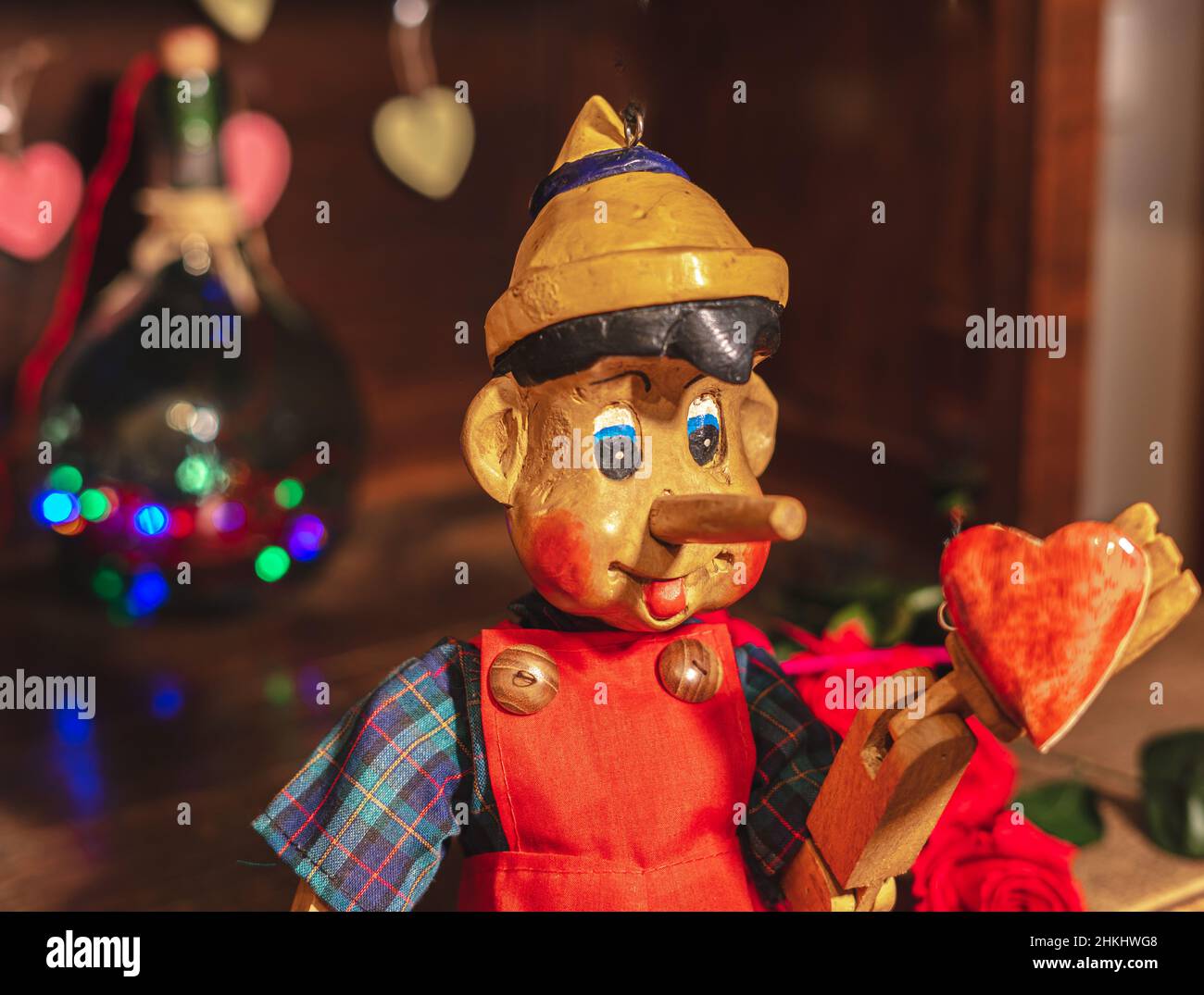 Pupazzo di legno a forma di Pinocchio che mostra un cuore anch'esso in legno Foto Stock