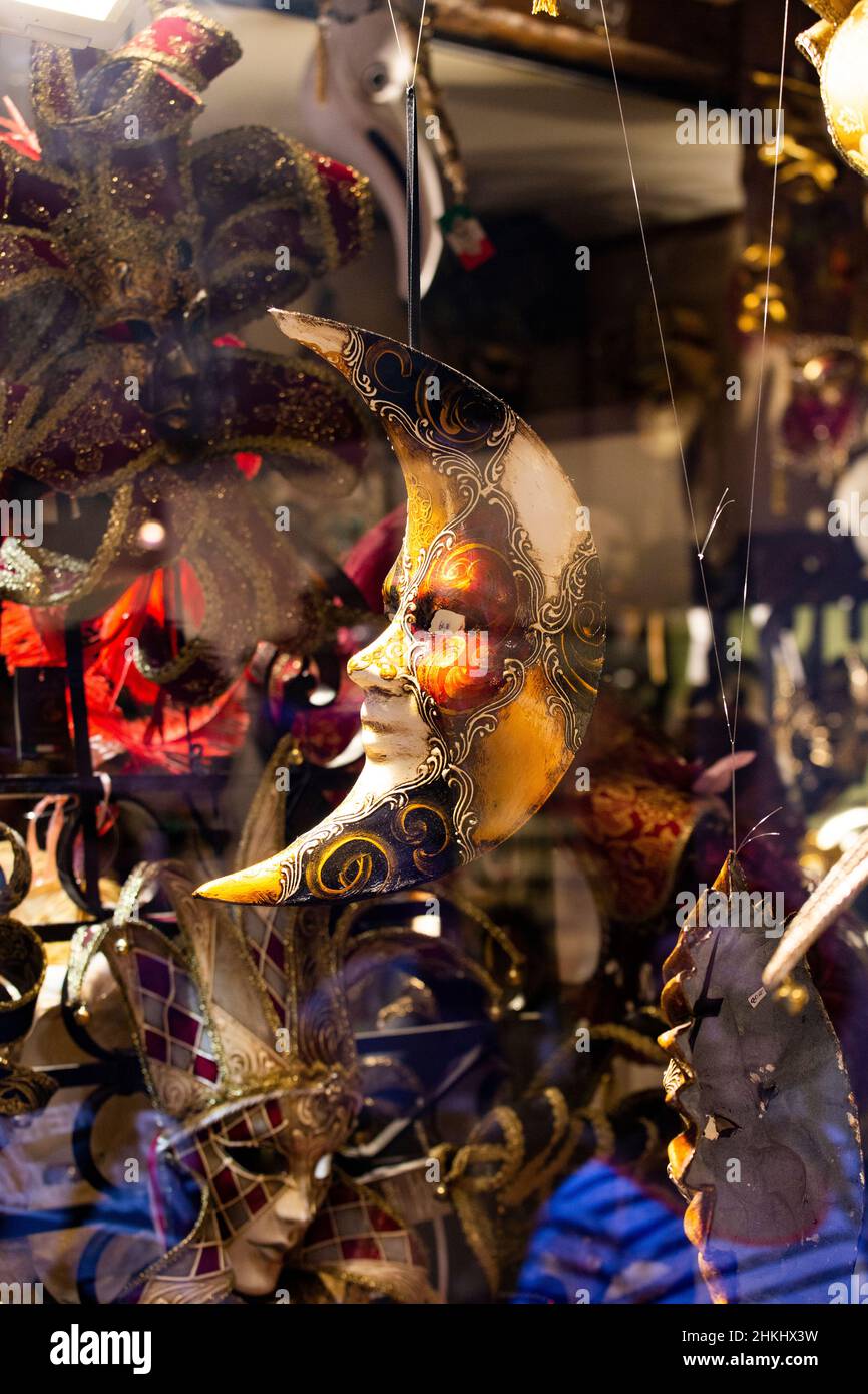 Maschera veneziana a forma di luna con un viso girato in un negozio di maschere veneziane Foto Stock