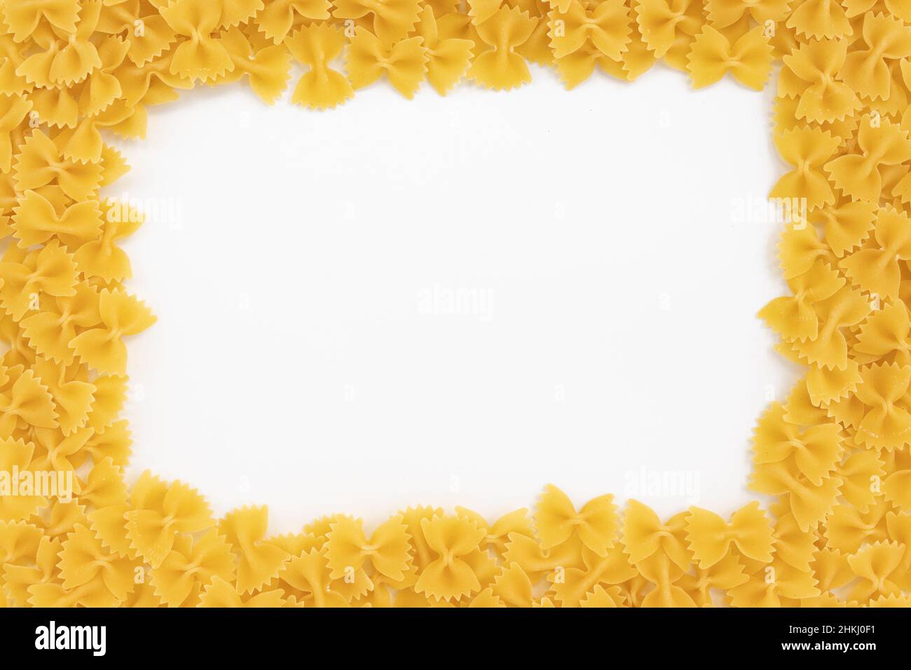 cornice di pasta italiana farfalle con spazio copia su sfondo bianco, primo piano, vista dall'alto Foto Stock