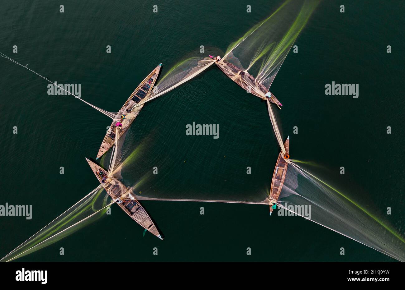 I pescatori locali pescano nel fiume con una rete enorme. Vista aerea scattata con il drone. Foto Stock
