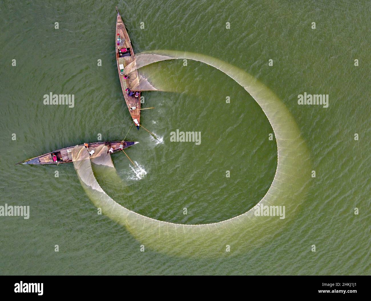 I pescatori locali pescano nel fiume con una rete enorme. Vista aerea scattata con il drone. Foto Stock