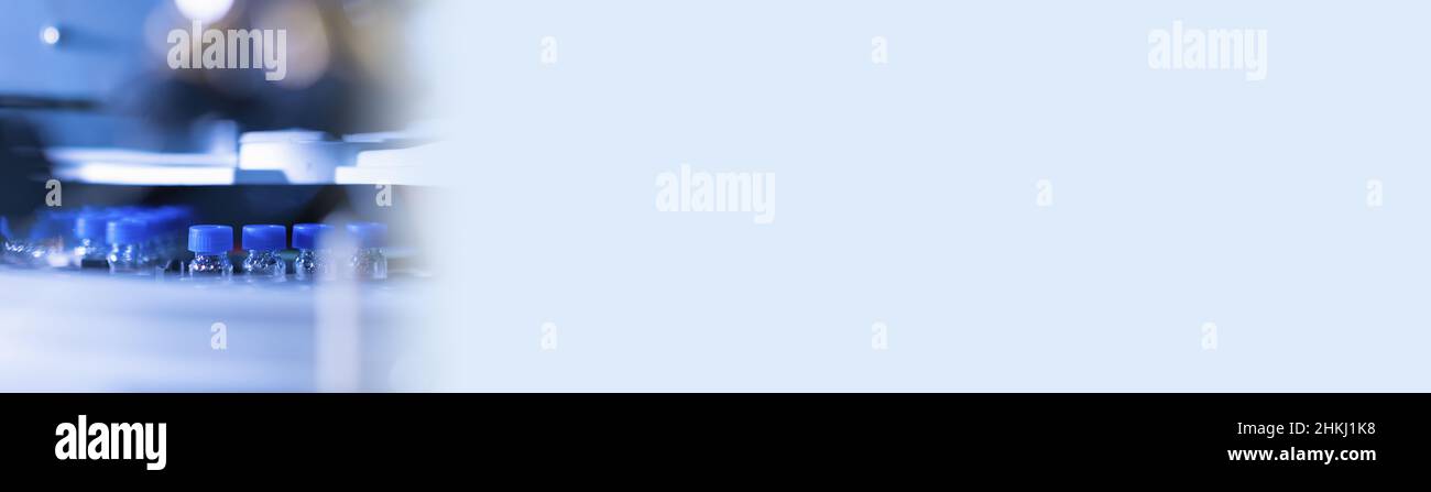 Striscione con fiale per HPLC nell'autocampionatore. Moderno laboratorio di chimica analitica. Foto Stock