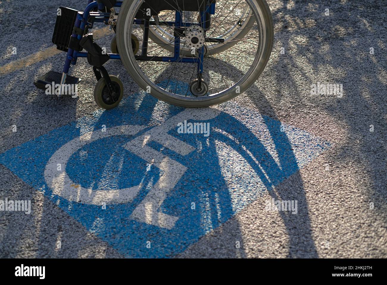Sedia a rotelle su parcheggio per disabili, spazio riservato, rispetto handicap Foto Stock