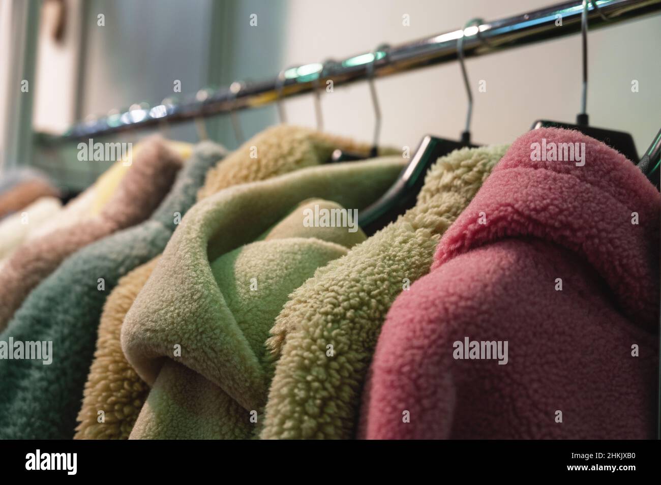 Eleganti cappotti e giacche in pelliccia sintetica appendono sul rack Foto Stock