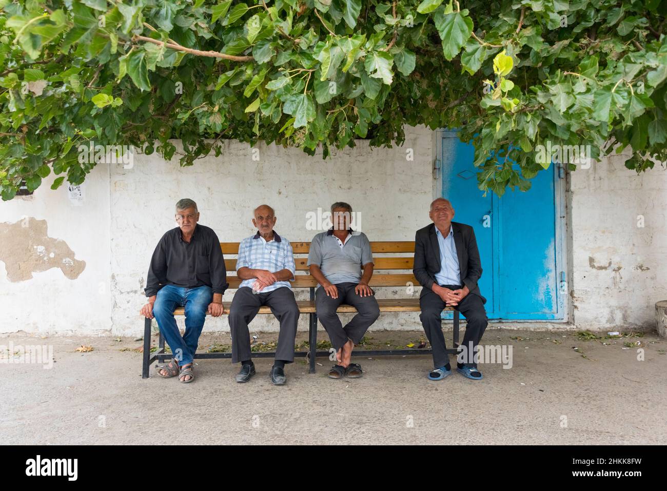 Vecchi uomini seduti su una panchina nella Città Vecchia, Baku, Azerbaijan Foto Stock