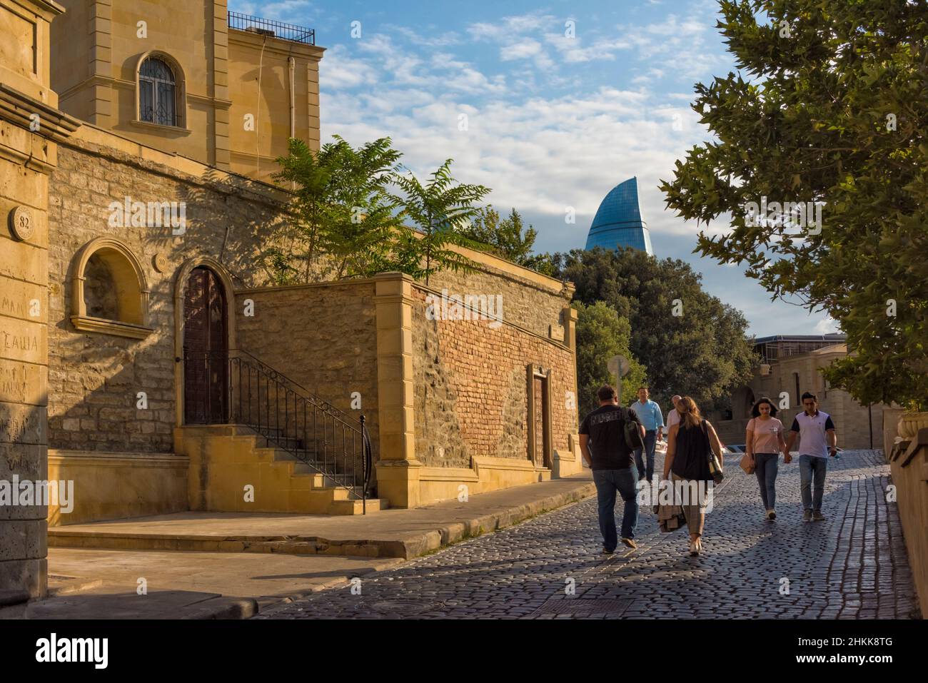 Vecchia casa e strada acciottolata nella Città Vecchia, Torri di fiamma in lontananza, Baku, Azerbaijan Foto Stock