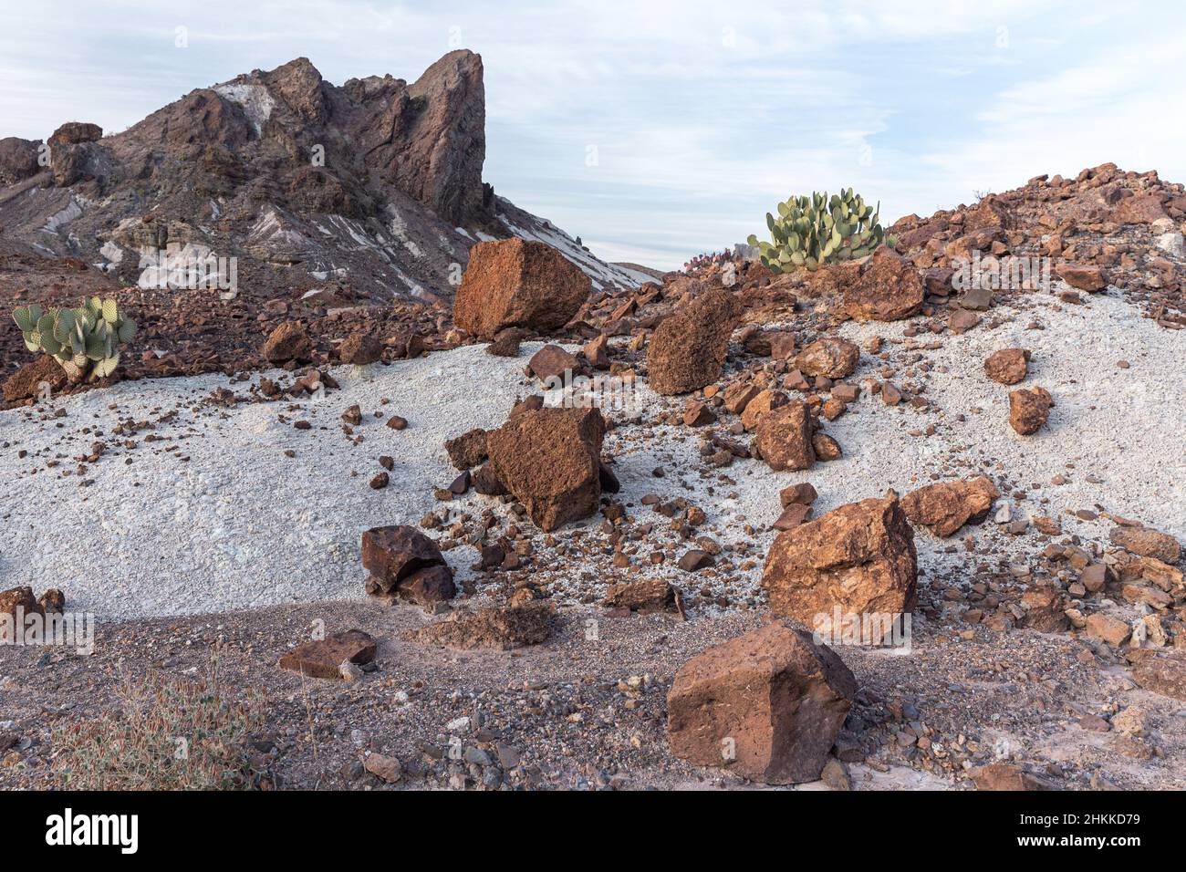 I massi rosso ruggine si rovesciano su una collina di cenere bianca. Foto Stock