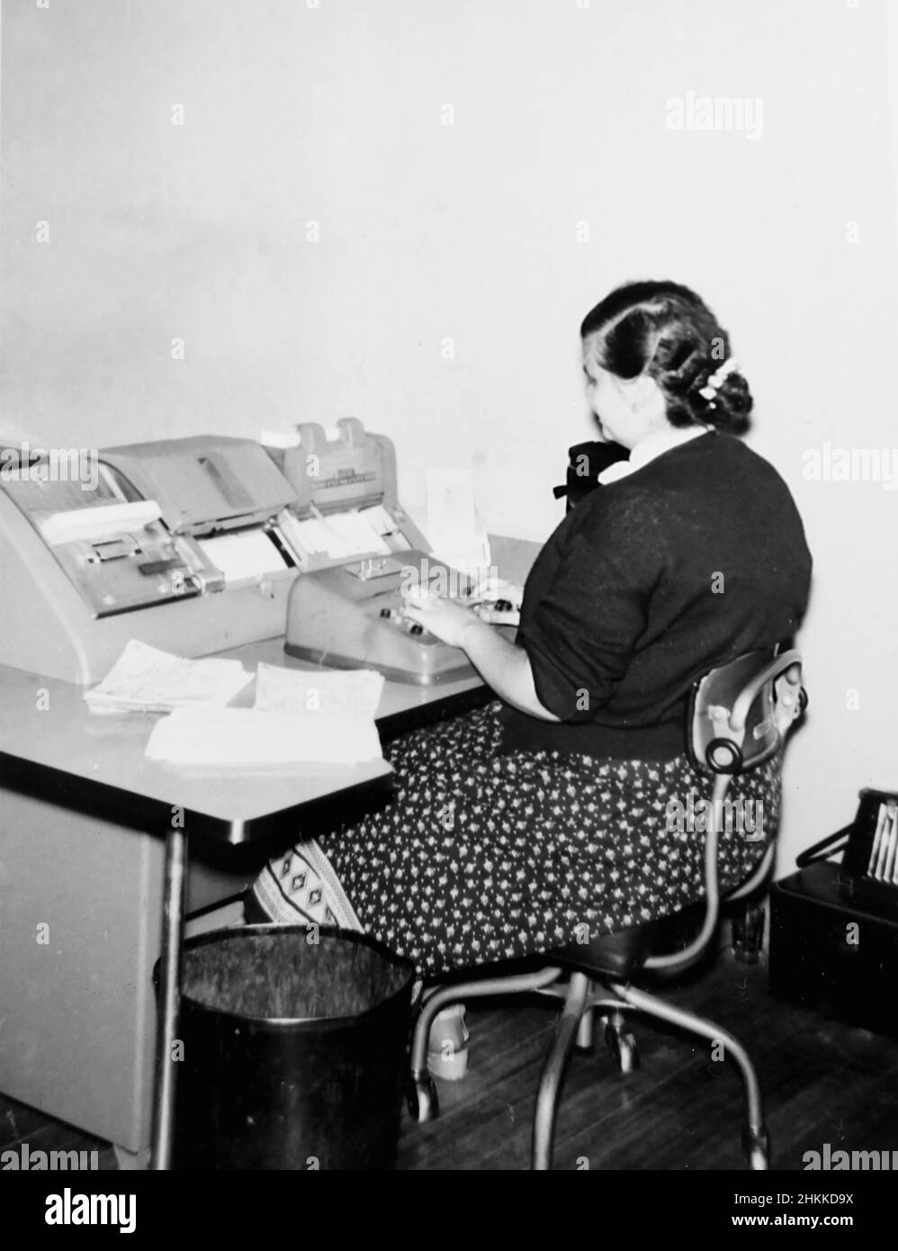 Un lavoratore in ufficio esegue l'elaborazione dei dati in anticipo alla sua scrivania, ca. 1962. Foto Stock