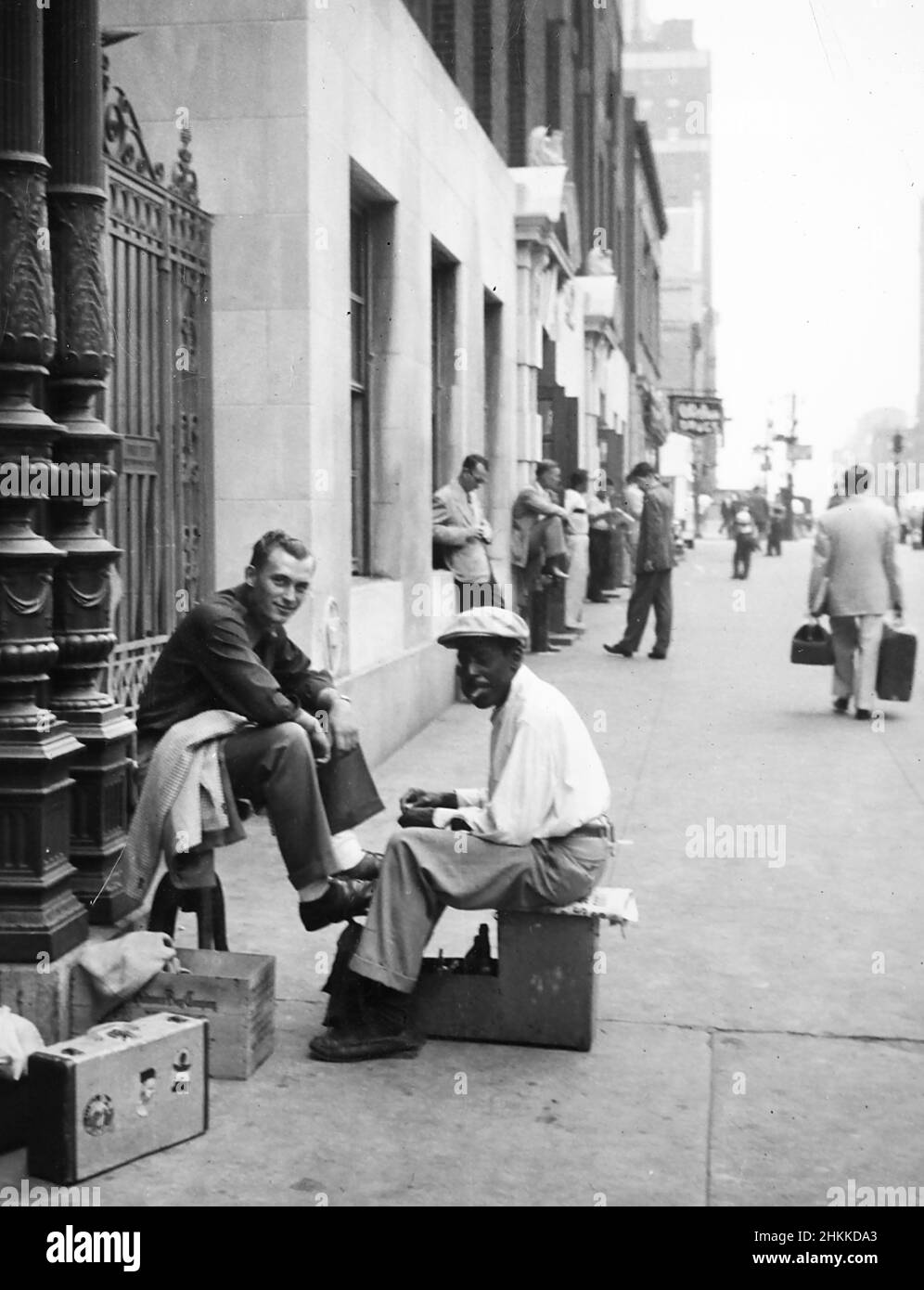 Un uomo ottiene una lucentezza della scarpa su un marciapiede di Chicago, ca. 1947. Foto Stock
