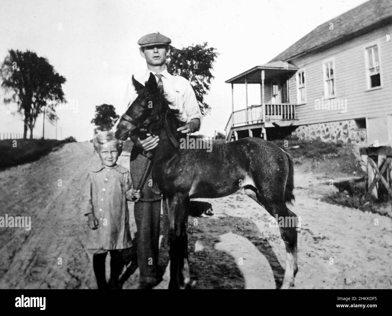Padre e figlia stanno con il loro nemico fuori dalla loro casa colonica, ca. 1932. Foto Stock