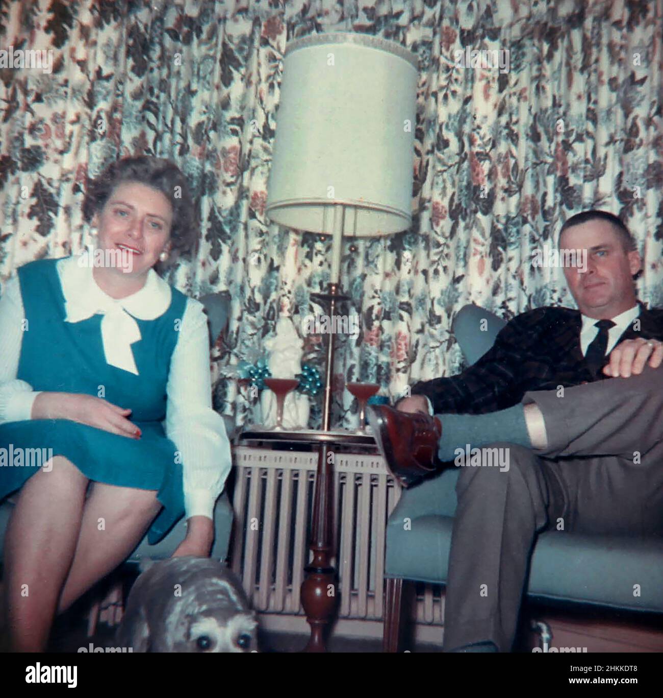Una coppia di mezza età posa davanti alcune tende brutte in una casa MCM, 1963. Foto Stock