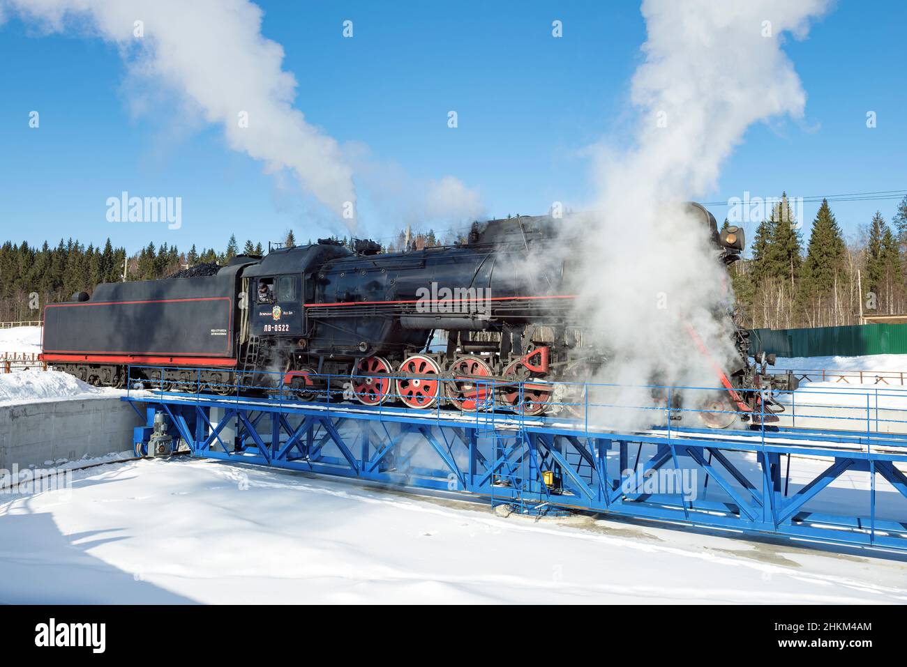 RUSKEALA, RUSSIA - 10 MARZO 2021: La vecchia locomotiva a vapore sovietica LV-0522 entra nel cerchio di svolta in un giorno di marcia soleggiato Foto Stock