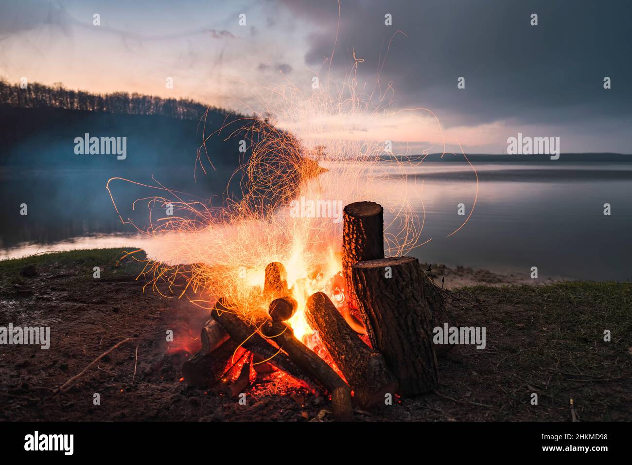 Falò con scintille fiamma al crepuscolo. Foto a lunga esposizione di scintille di fuoco. Foto Stock