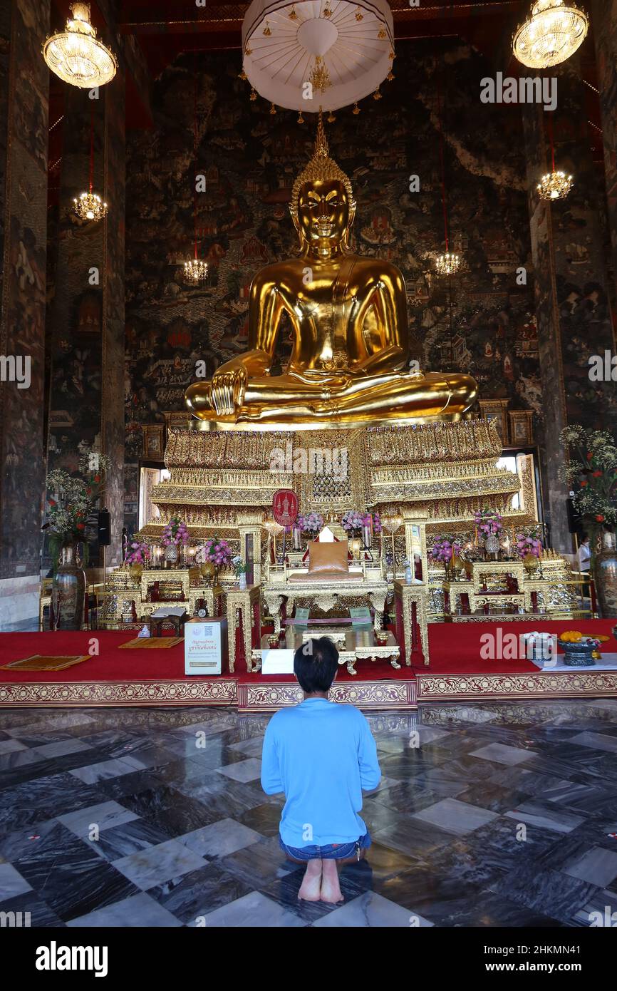 Uomo in preghiera a Wat Suthat Thepwararam, tempio buddista con buddha d'oro, Wat Suthat, Bangkok, Thailandia Foto Stock