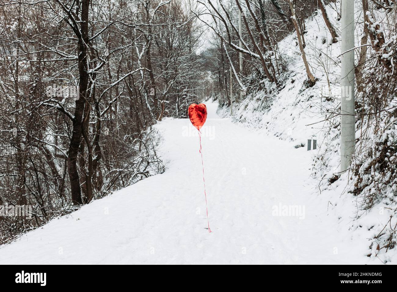 Mongolfiera di elio a cuore rosso sulla strada. San Valentino Foto Stock