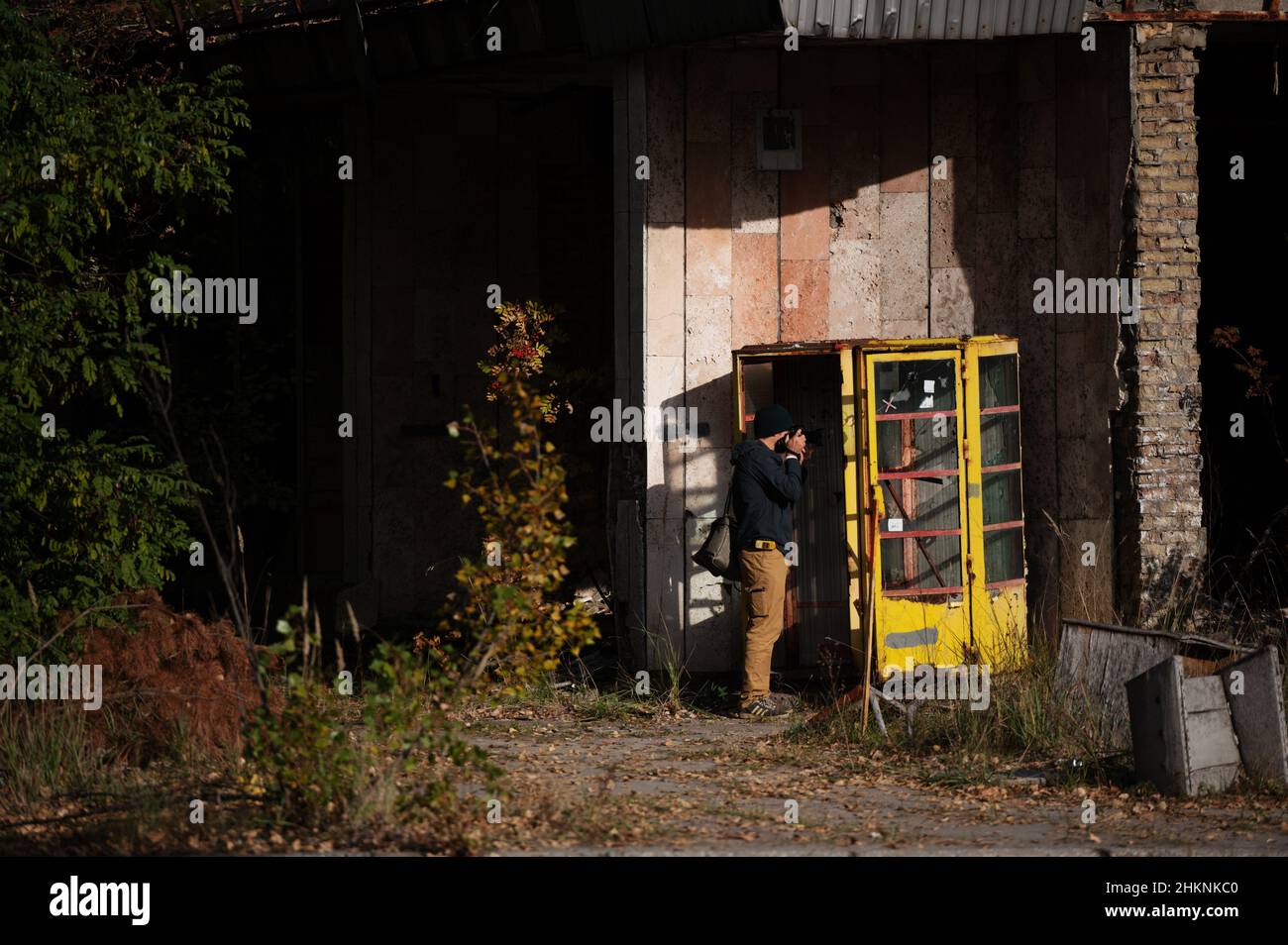 Un turista fotografa una cabina telefonica in abbandonato Pripyat, Ucraina anni dopo il disastro nucleare di Chernobyl. Foto Stock